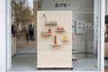 Module Vitrine Aire – présentoir pegboard double face en bouleau avec rangement à casiers sur roulettes en boutique