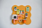 Pegboard Curves orange pastel avec dessins accrochés aux clips magnétiques verts