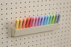 Tilting highlighter holder tipped forward on a wooden pegboard - Aire
