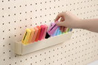 Hand taking a pastel highlighter from the tilting pegboard holder - Aire