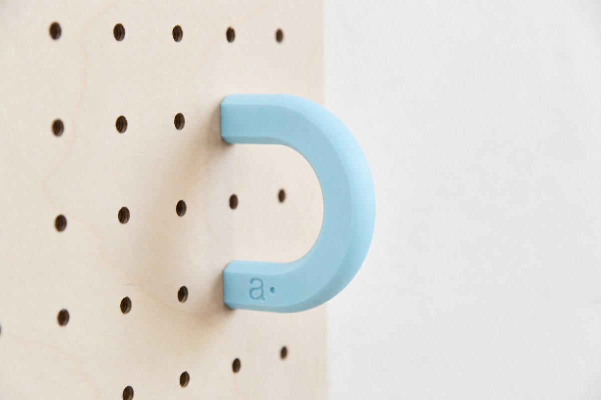 Anneau coloré bleu ciel taille M sur un pegboard en bouleau