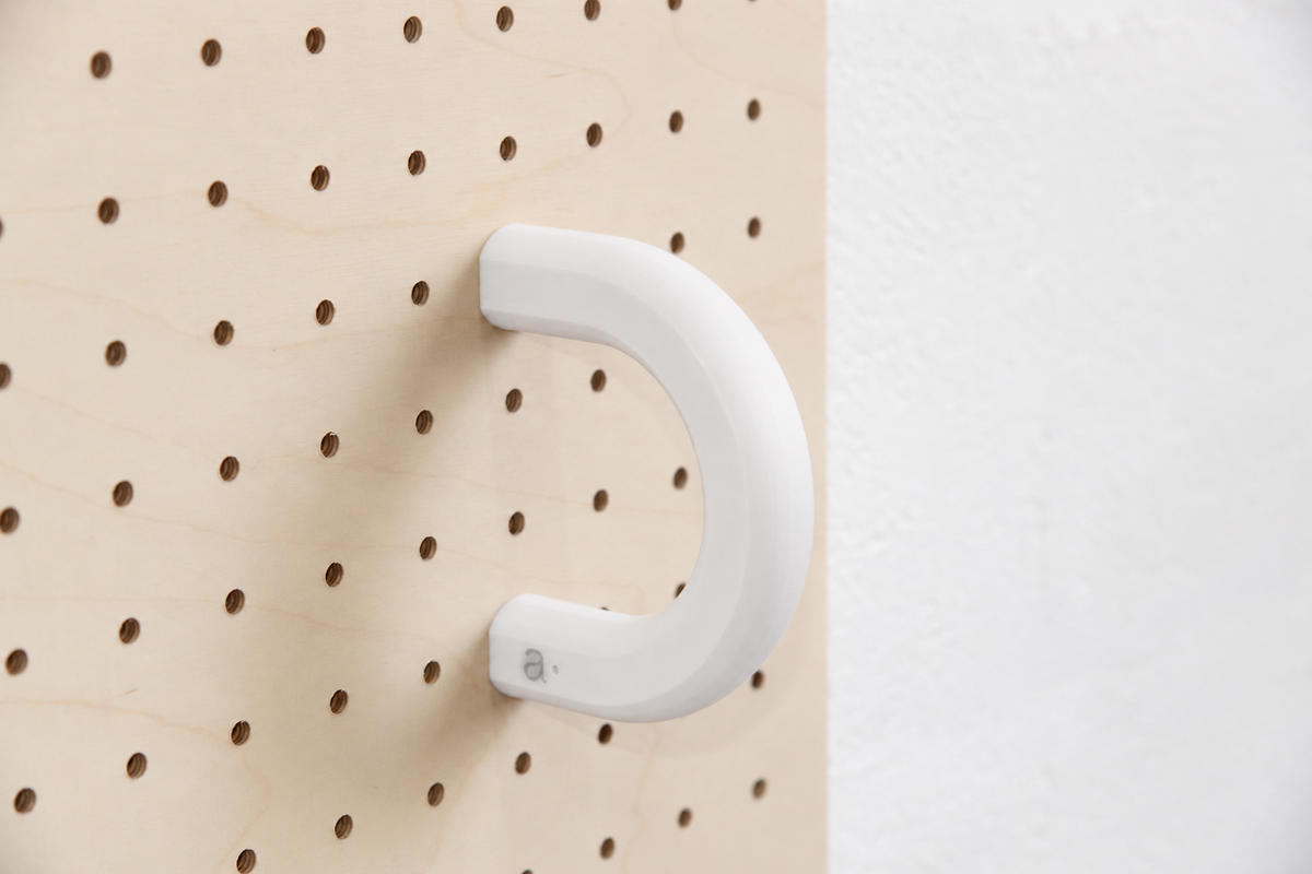 Anneau coloré blanc taille L sur un pegboard en bouleau