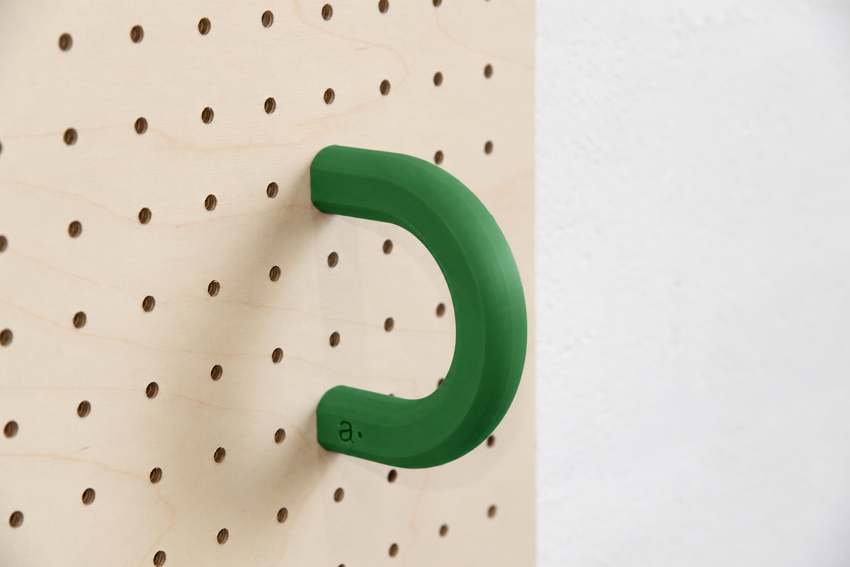 Anneau coloré vert taille L sur un pegboard en bouleau
