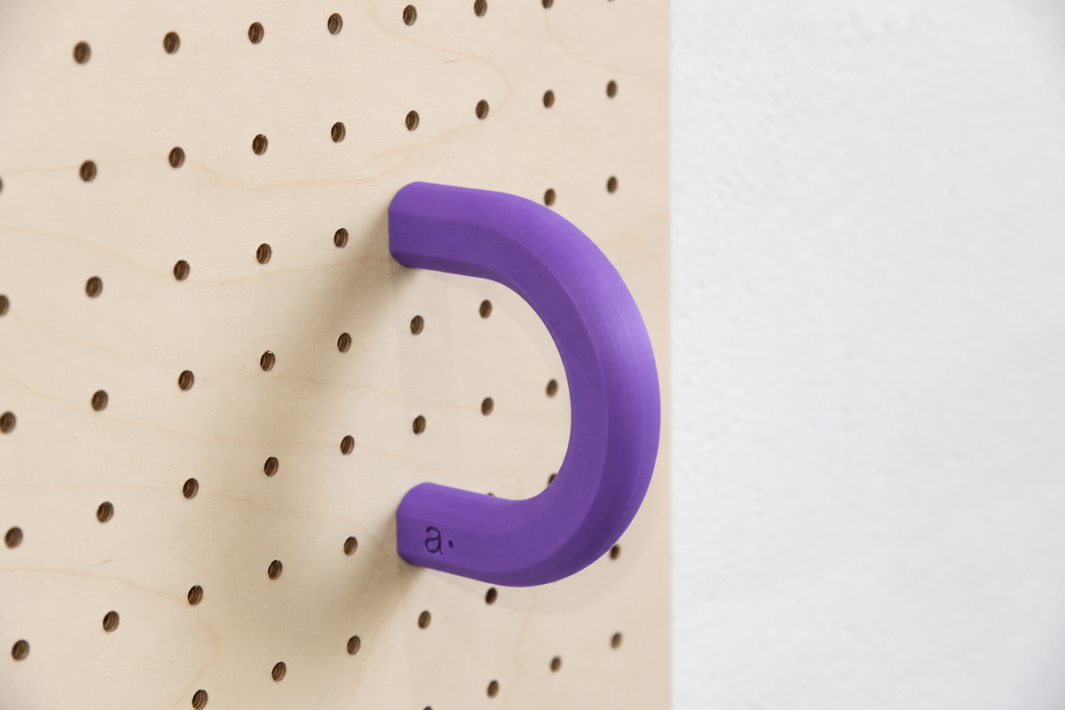 Anneau coloré violet taille L sur un pegboard en bouleau