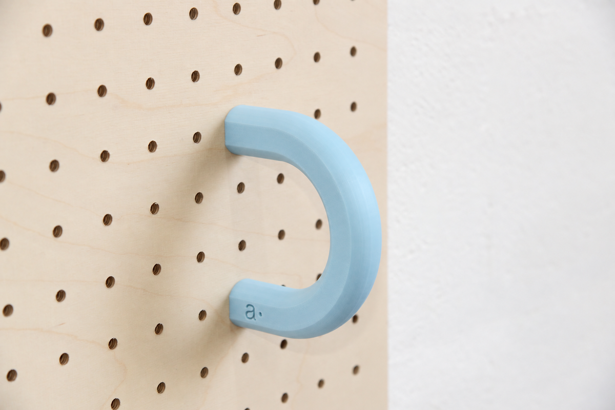 Anneau coloré bleu ciel taille L sur un pegboard en bouleau