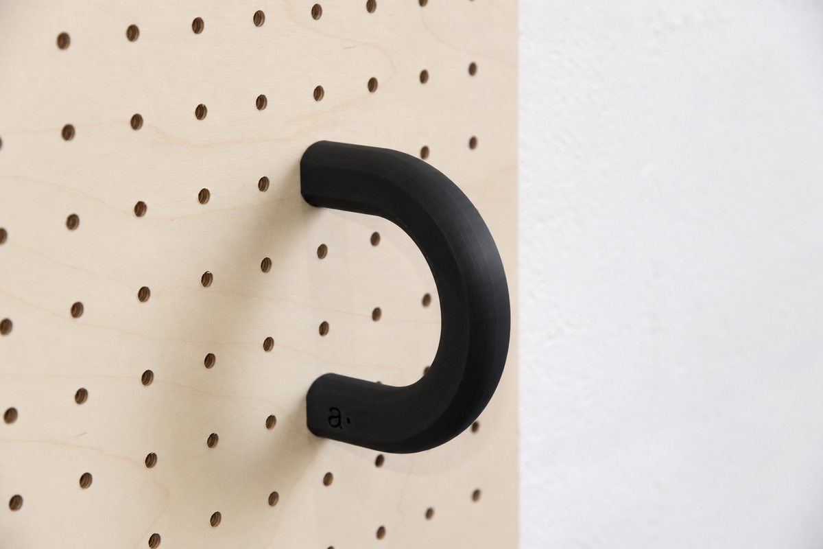 Anneau coloré noir taille L sur un pegboard en bouleau
