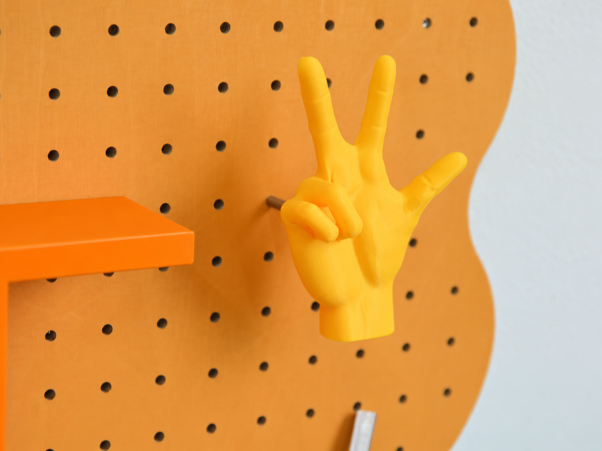 Patère main imprimée en 3D accrochée au pegboard Curves orange pastel