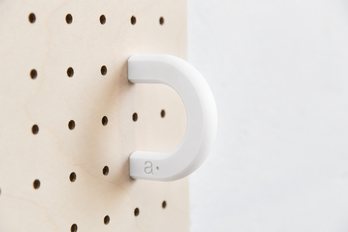Anneau coloré blanc taille M sur un pegboard en bouleau