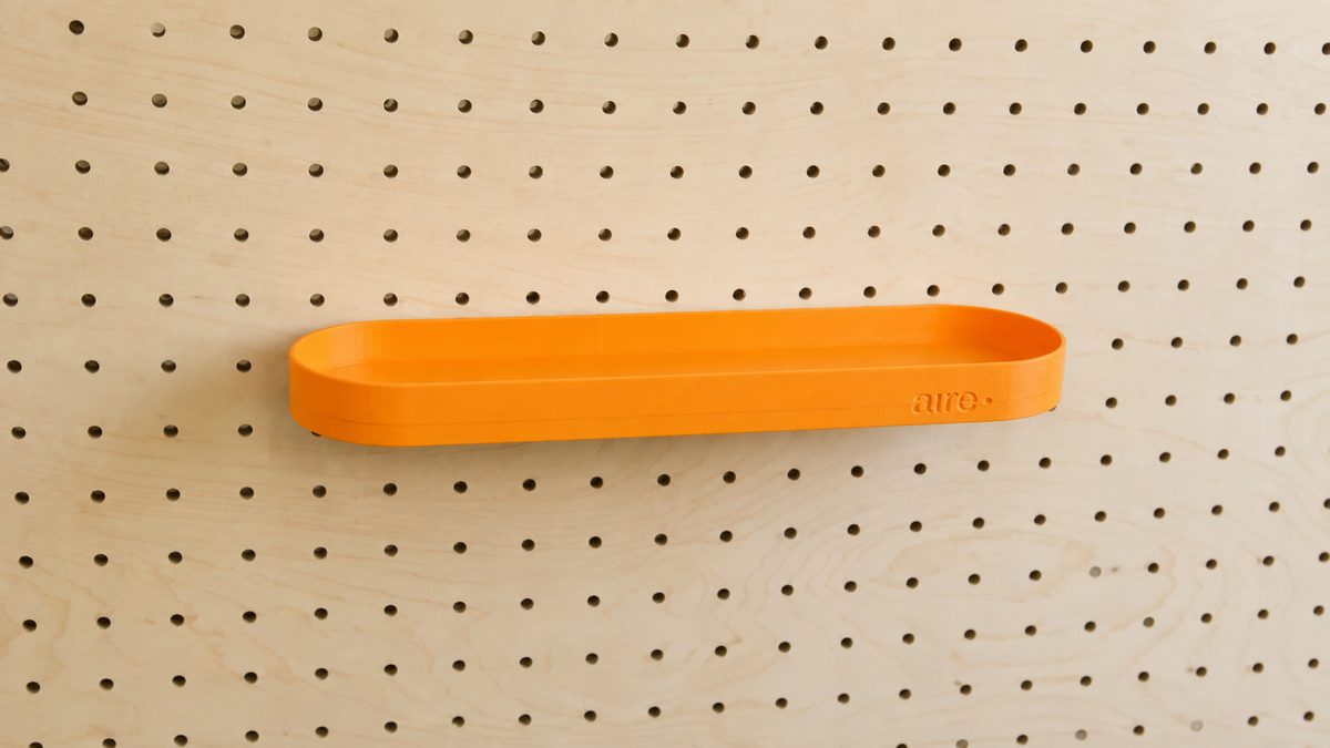 Étagère avec rebords arrondie orange sur pegboard en bouleau