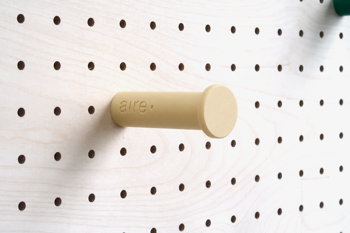 Beige wall hook on a birch pegboard
