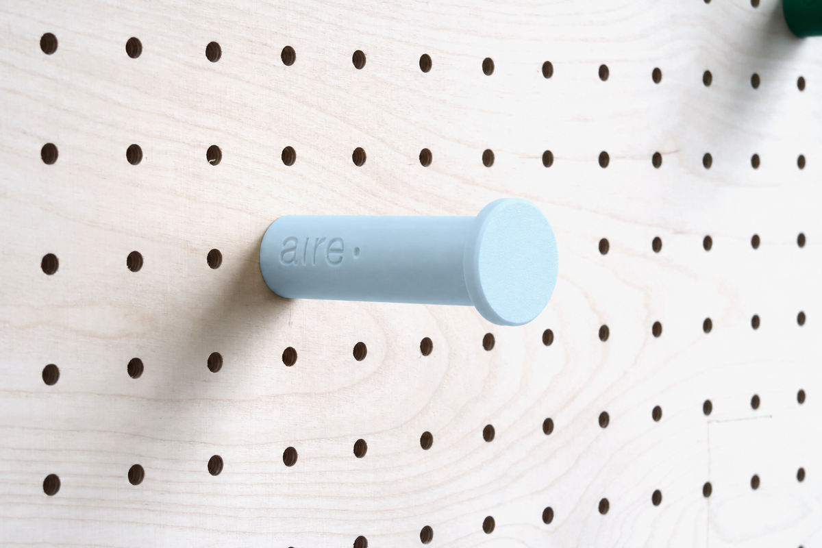 Sky blue wall hook on a birch pegboard