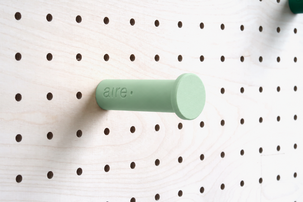 Aqua green wall hook on a birch pegboard