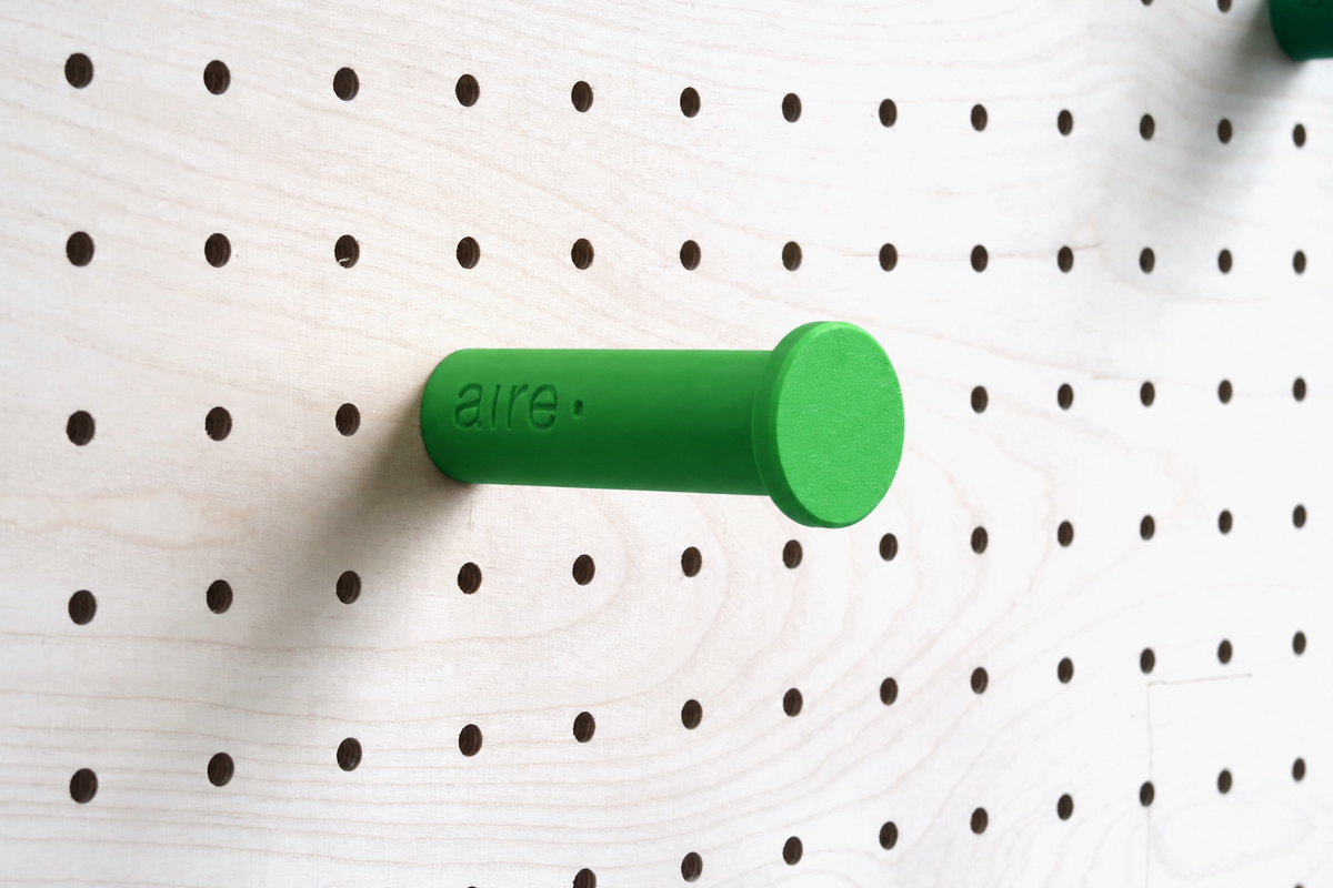 Green wall hook on a birch pegboard