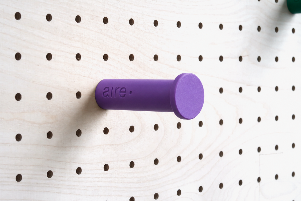 Purple wall hook on a birch pegboard