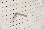 Aire wall cap holder on a wooden pegboard – notched stainless steel and bioplastic rod